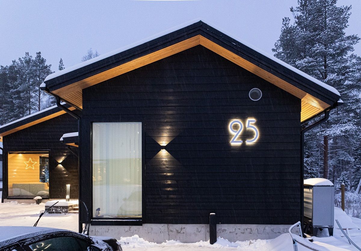 Le luci a parete che si riflettono sul rivestimento chiaro della grondaia migliorano l'aspetto di una casa buia